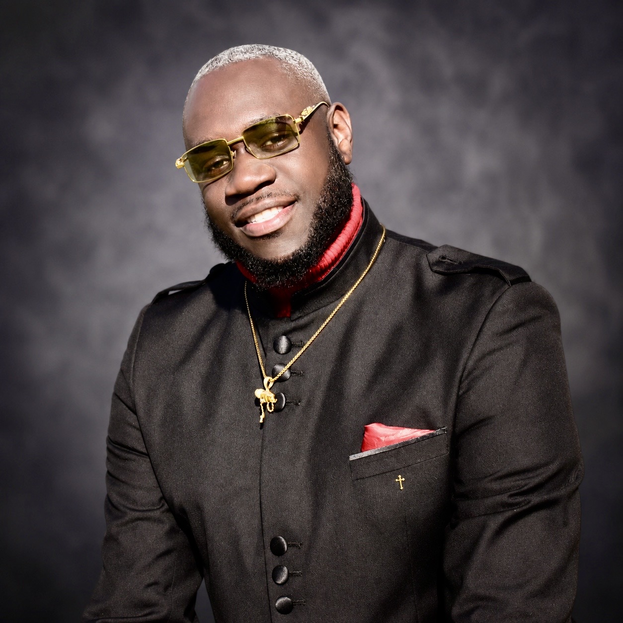 Pastor Albert L. Polk IV in a black clergy suit with gold accents